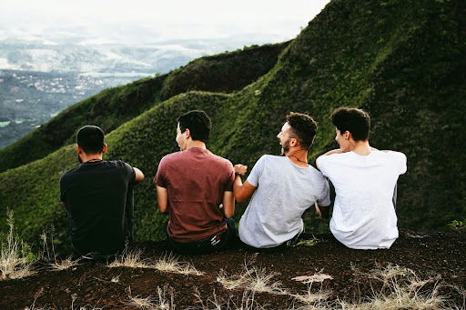 four people hanging out on top of a mountain